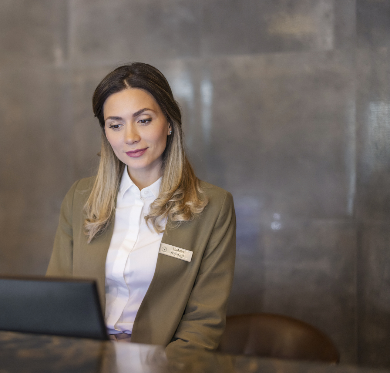 Female trainee working at a hotel's reception desk